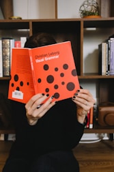 person holding orange and white polka dot paper