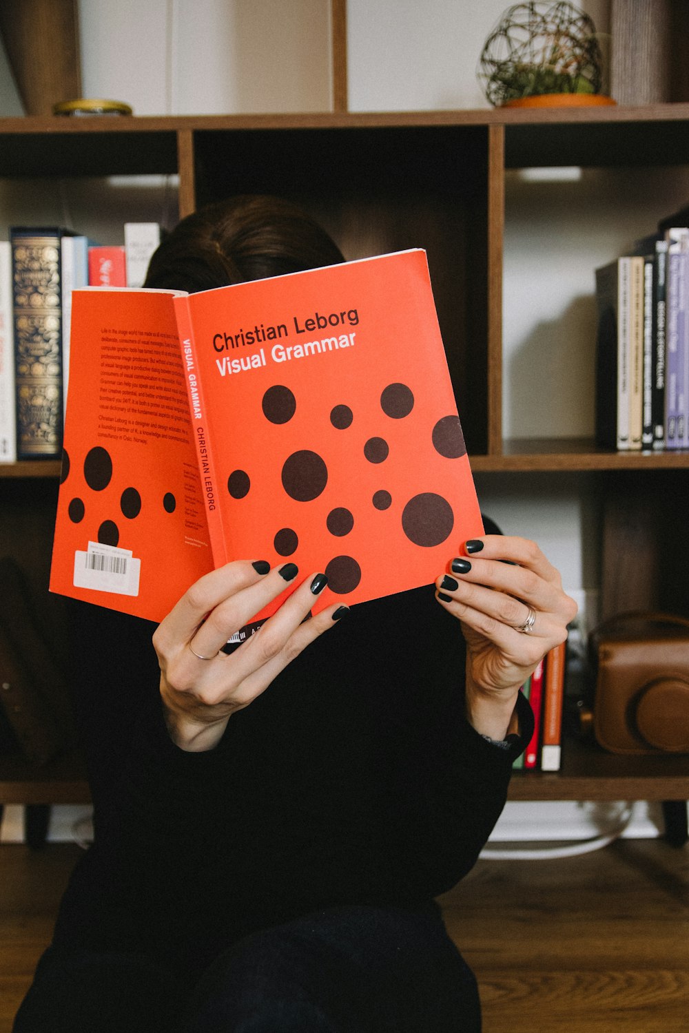 person holding orange and white polka dot paper