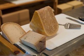 A cheese expert presenting a selection of fine cheeses on a wooden board.