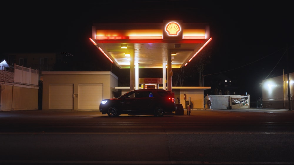 black sedan parked in front of white and red building during night time