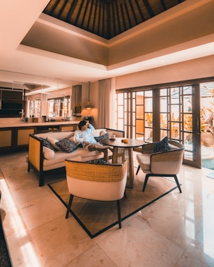 woman in white shirt sitting on brown couch
