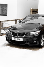 black mercedes benz c class on snow covered ground during daytime