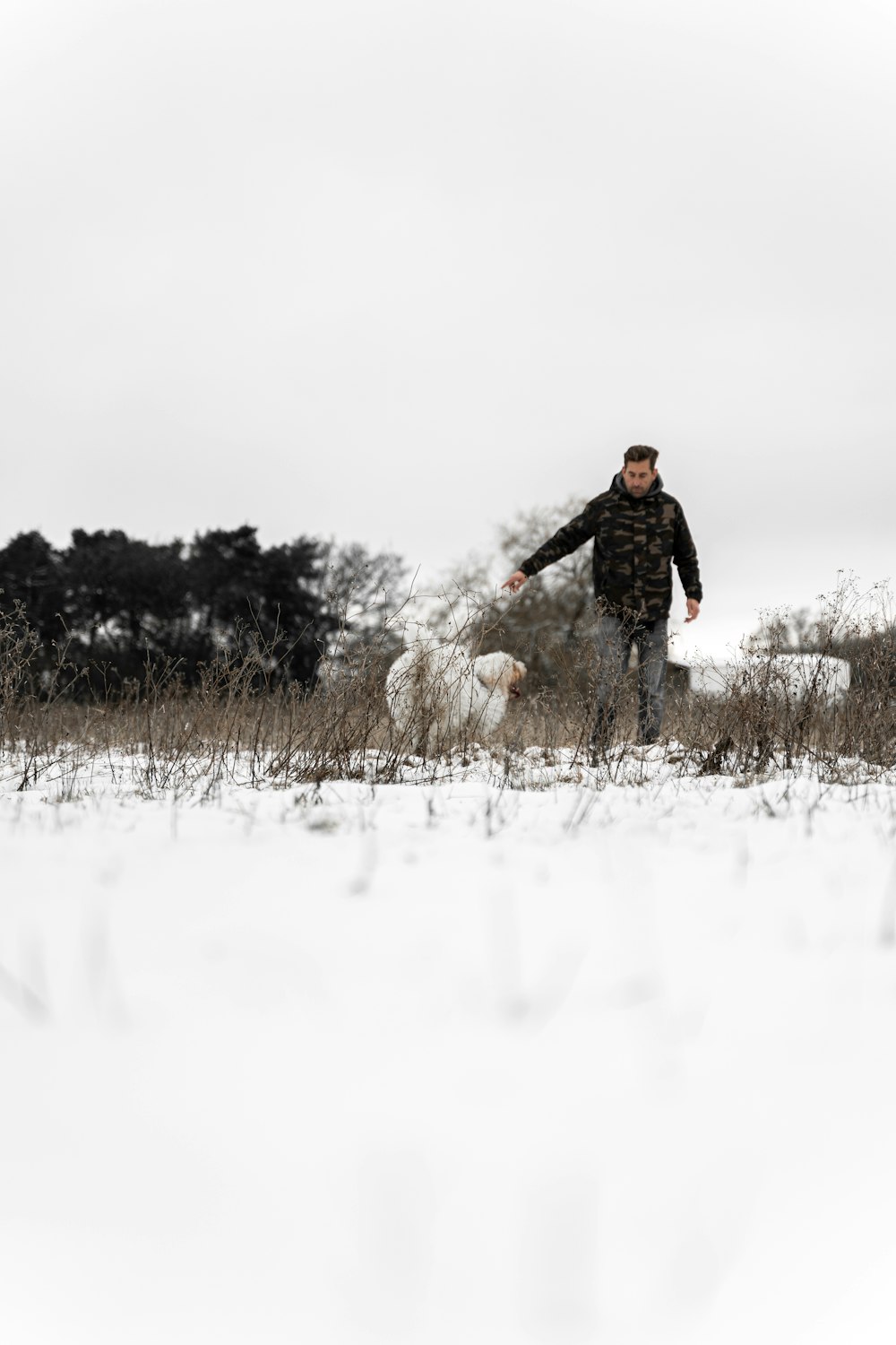 woman in black coat standing on snow covered field during daytime