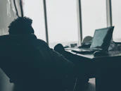 A candid shot of the CEO working at their desk with a laptop and notes.