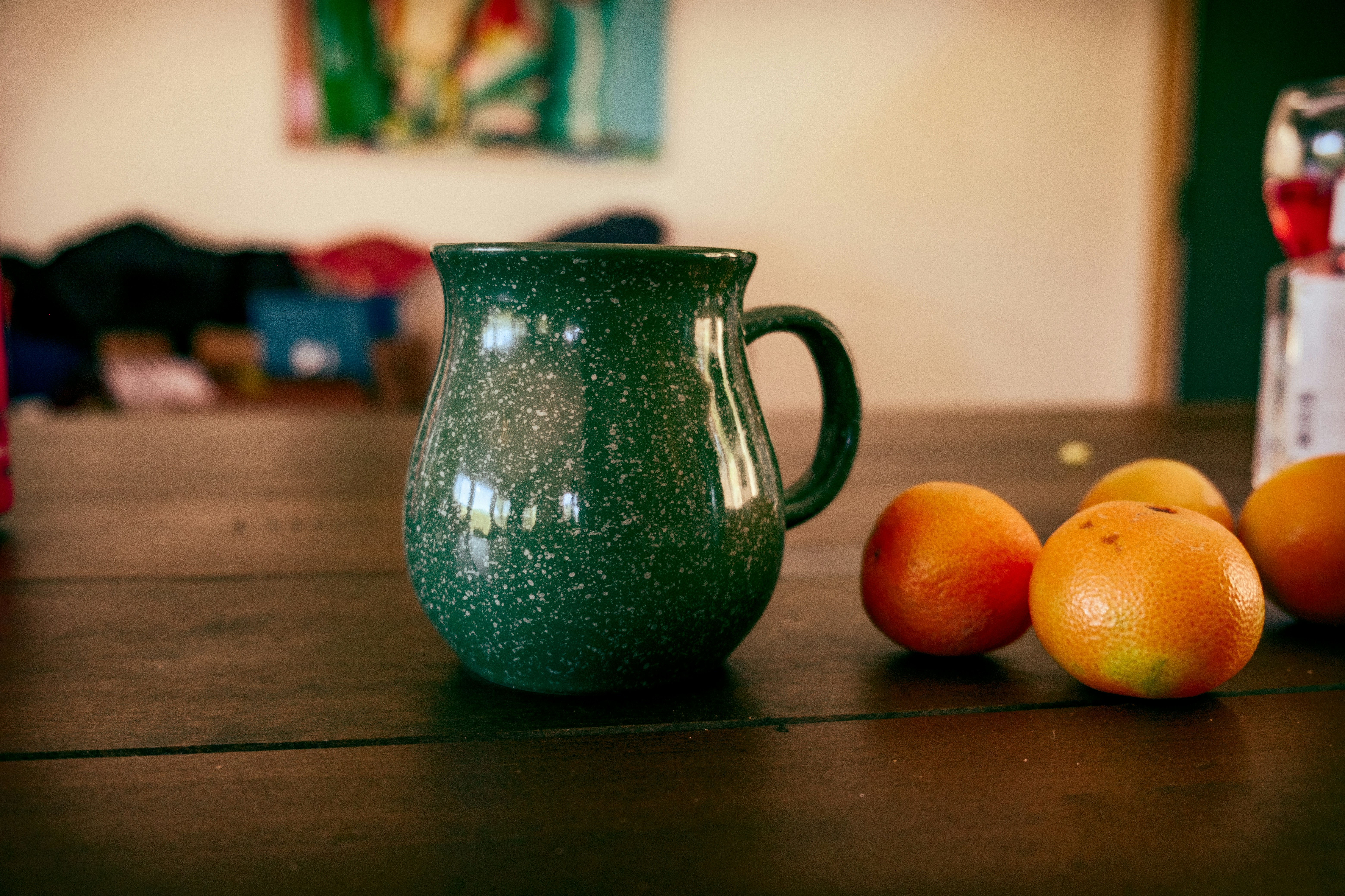 green ceramic pitcher on brown wooden table