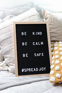 A set of home goods including pillows and blankets, each with thoughtful, positive messages.