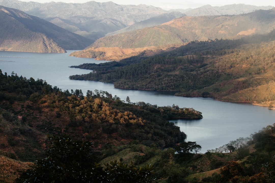 green and brown mountains beside body of water during daytime