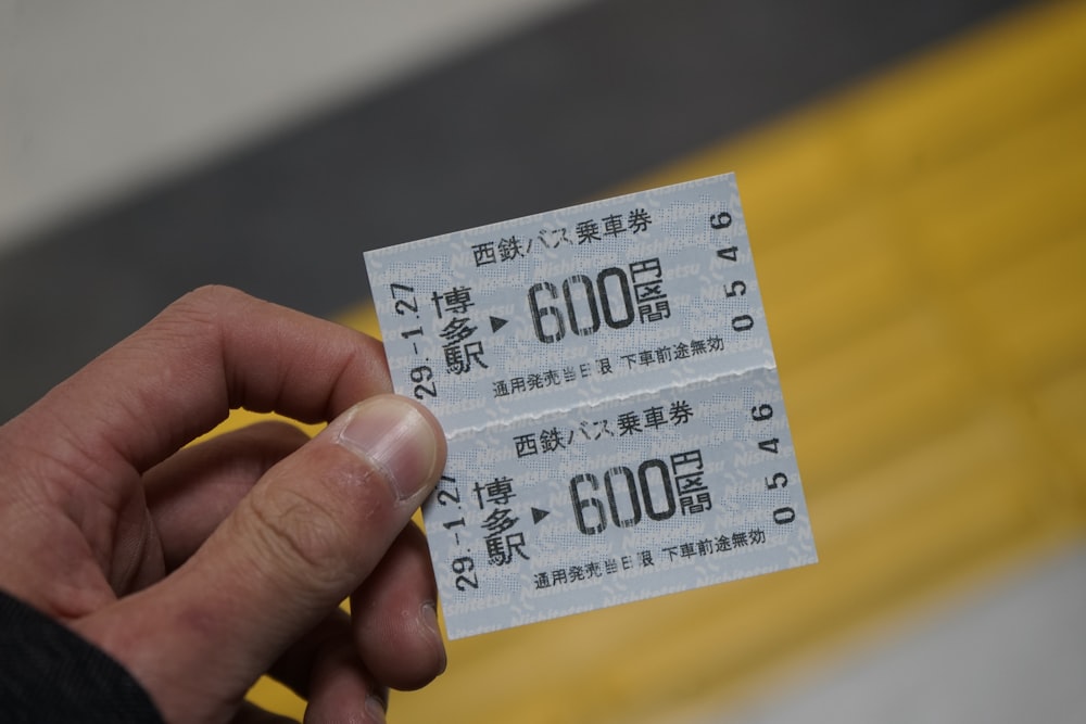 person holding white and black ticket