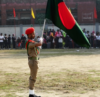 man in green uniform holding red and green flag