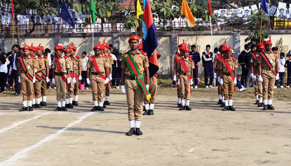 men in green and brown uniform standing on gray concrete floor during daytime