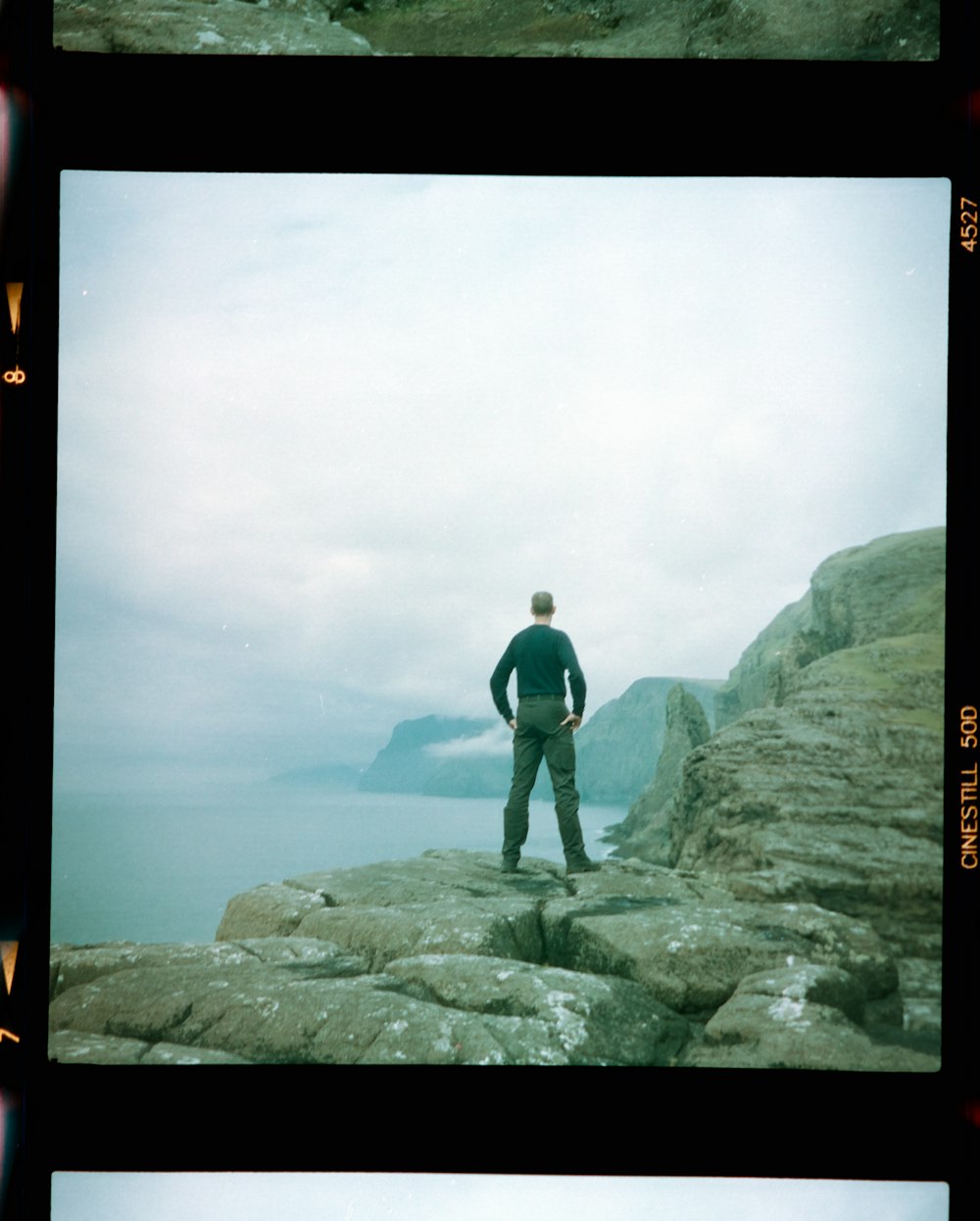 man in black jacket standing on rock
