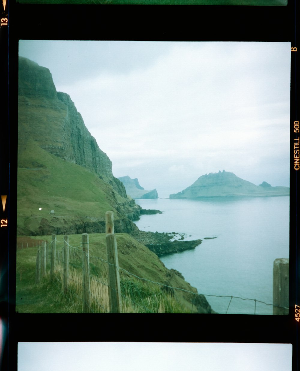 green and brown mountain beside body of water during daytime