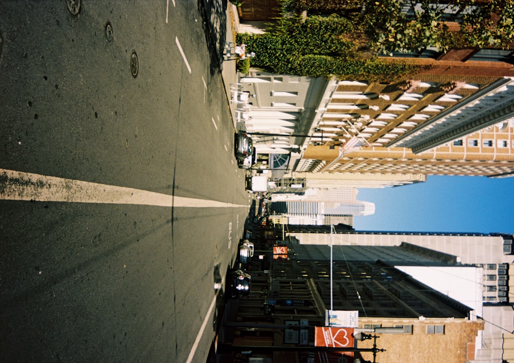 cars parked on side of the road in between high rise buildings during daytime