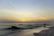 A serene couple holding hands on a beach at sunset, symbolizing hope and calm.