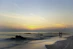 A serene couple holding hands on a beach at sunset, symbolizing hope and calm.