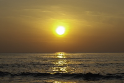 Sunset view from a boat with calm sea and warm golden light over Mallorca coastline.