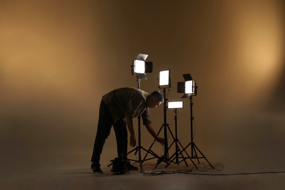 man in black long sleeve shirt and black pants standing beside black tripod