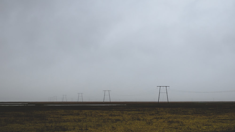 wind turbines on brown field under white sky during daytime