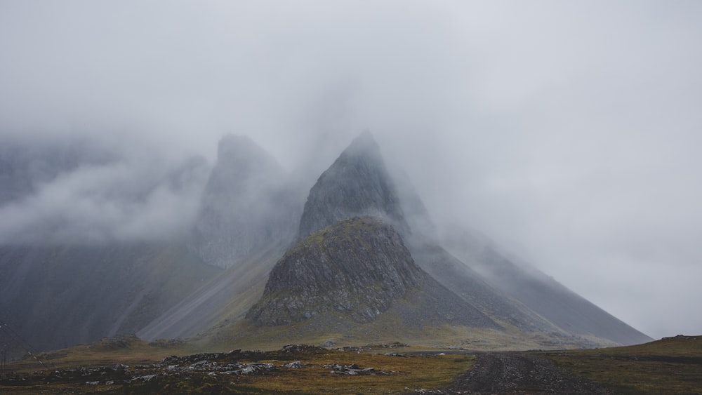 brown mountain covered by white clouds