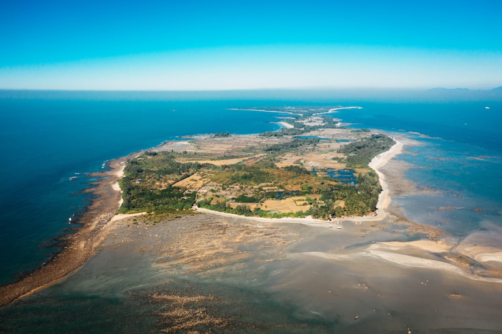 Luftaufnahme von grünem und braunem Land in der Nähe des blauen Meeres während des Tages
