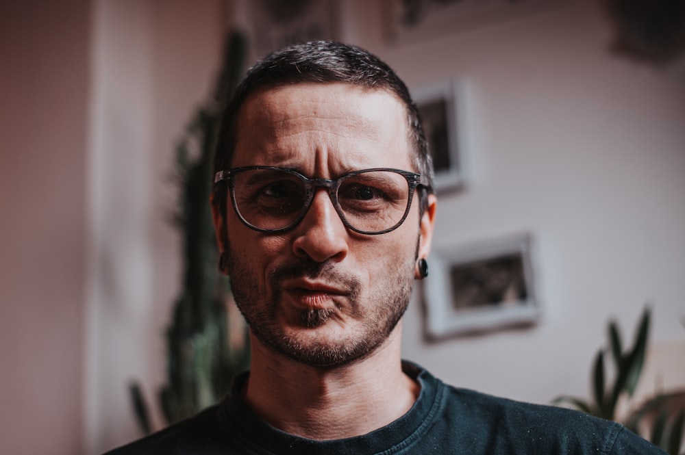 man in black crew neck shirt wearing black framed eyeglasses