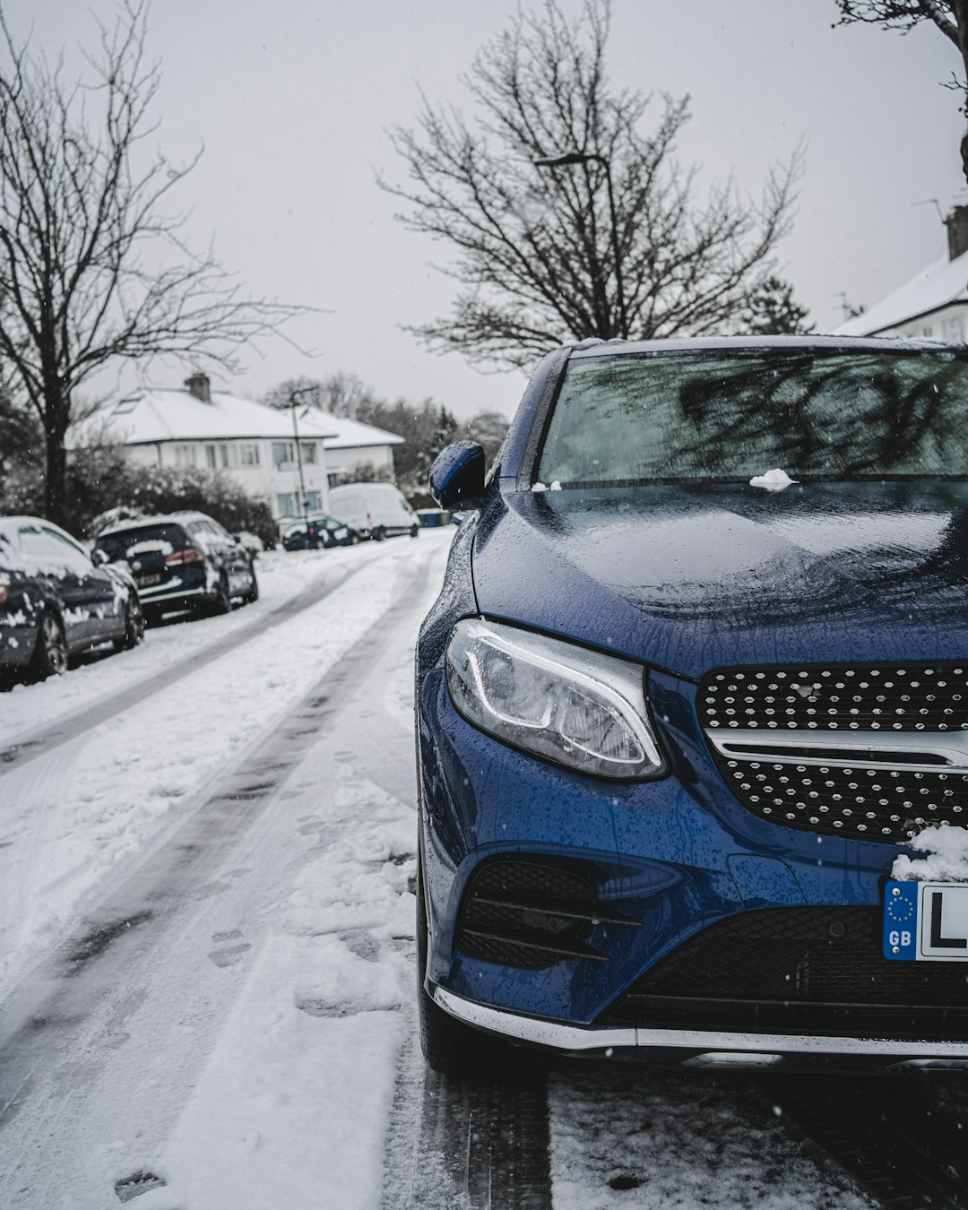 blue car on snow covered road during daytime