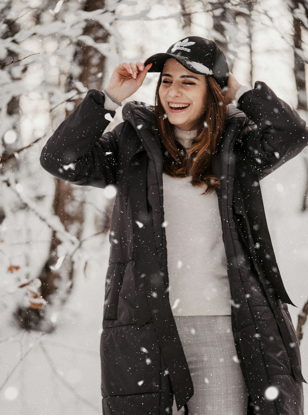 woman in black coat standing on snow covered ground during daytime