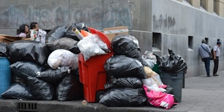 black plastic garbage bag on red plastic trash bin