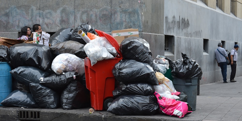 black plastic garbage bag on red plastic trash bin