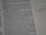 A close-up of hands flipping through a printed manuscript.
