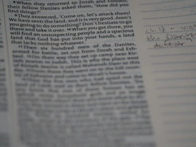 A close-up photo of an open manuscript page with neat handwritten notes in dark ink on cream paper.