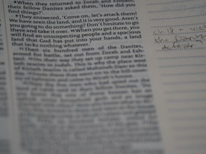 Close-up of hands writing sermon notes on aged parchment paper.