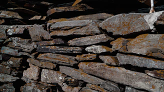 Close-up of skilled mason working on stone wall with traditional tools.