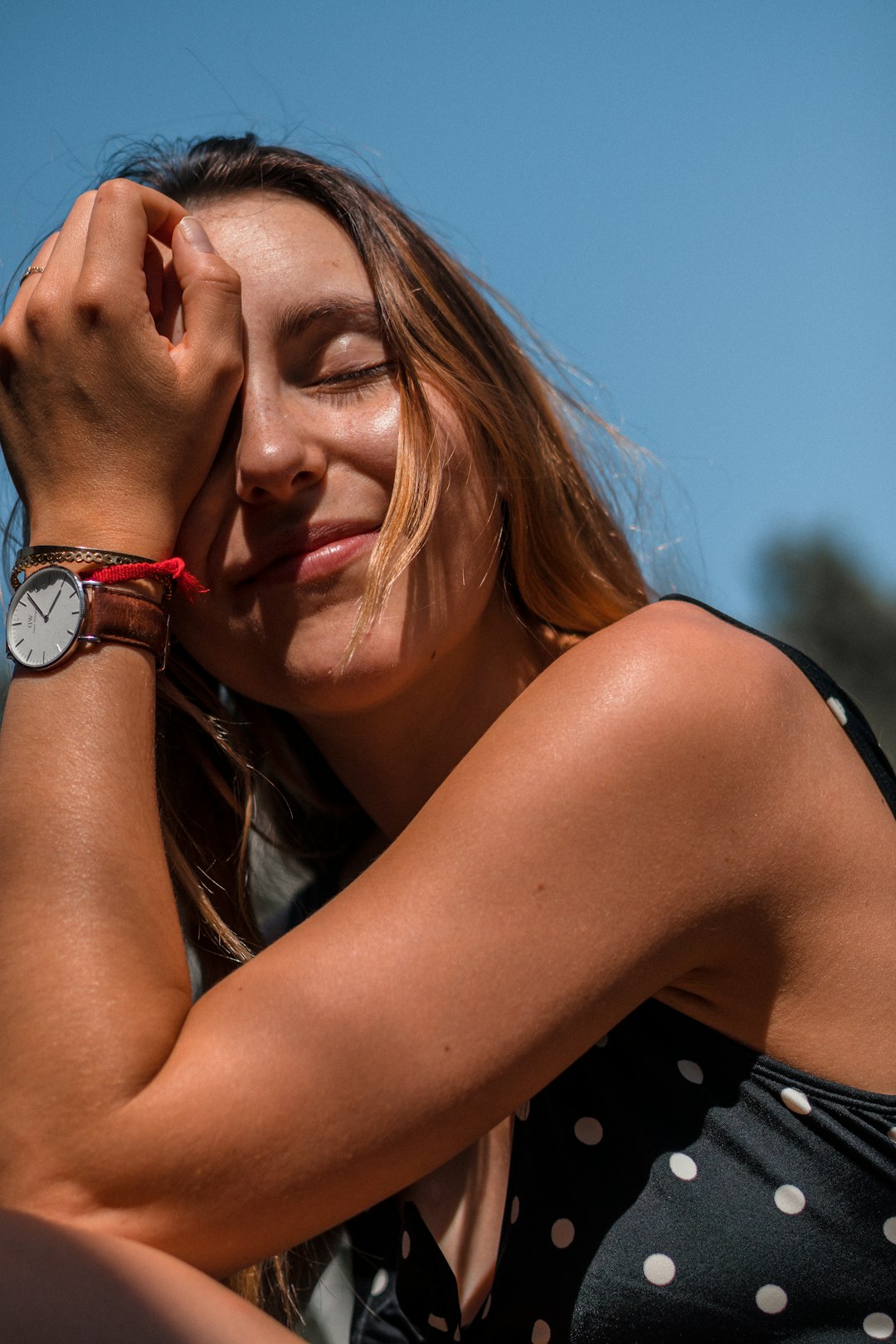 woman in black tank top wearing blue and red watch