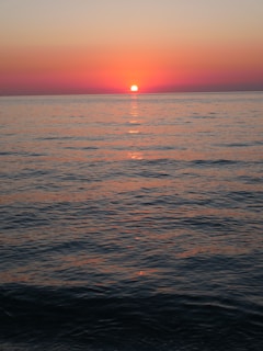 A stunning sunset over a calm ocean, reflecting warm hues.