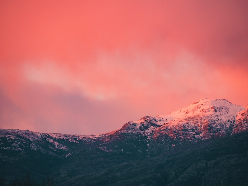 black and white mountain under orange sky