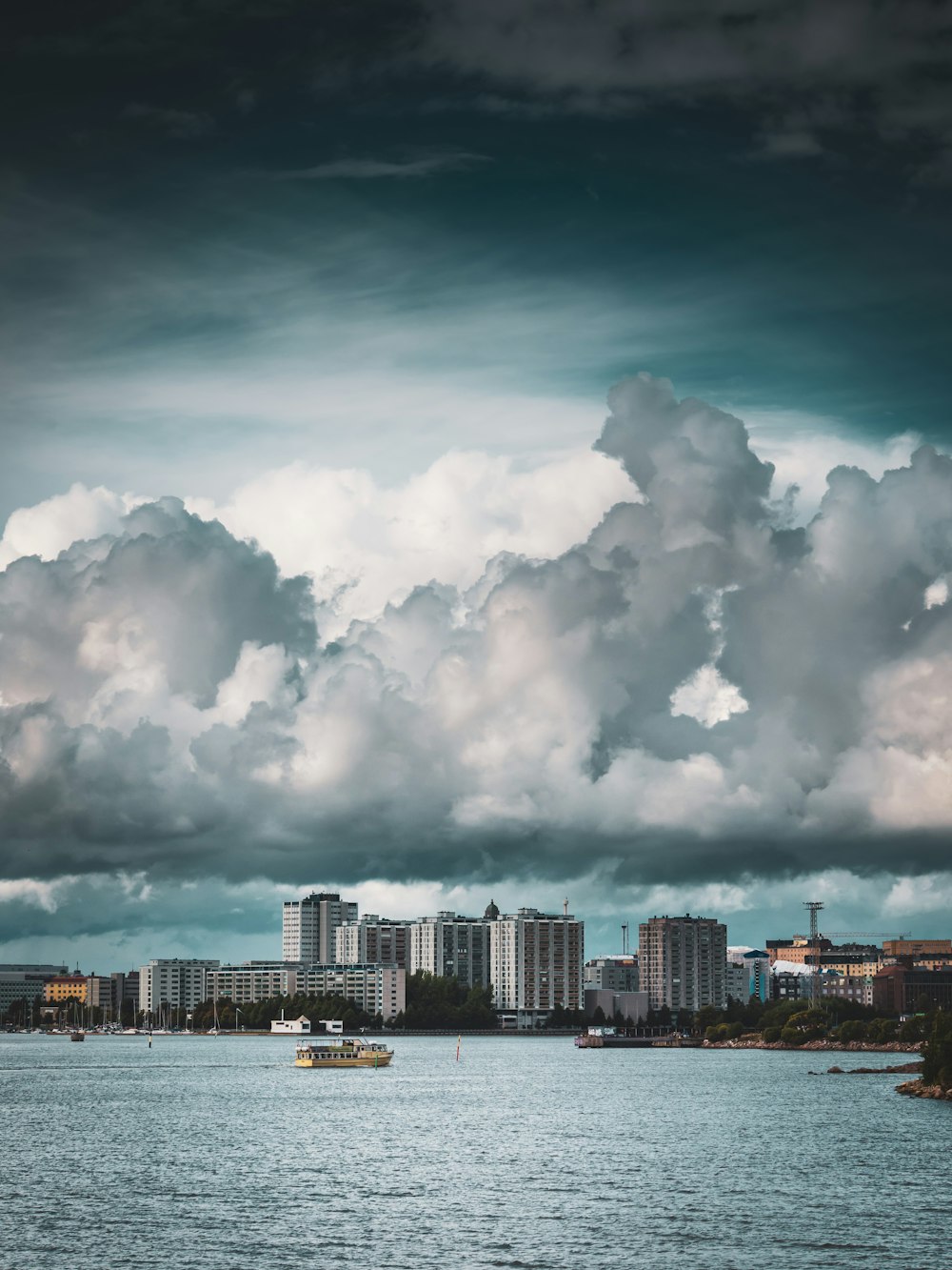 city skyline under white clouds and blue sky during daytime