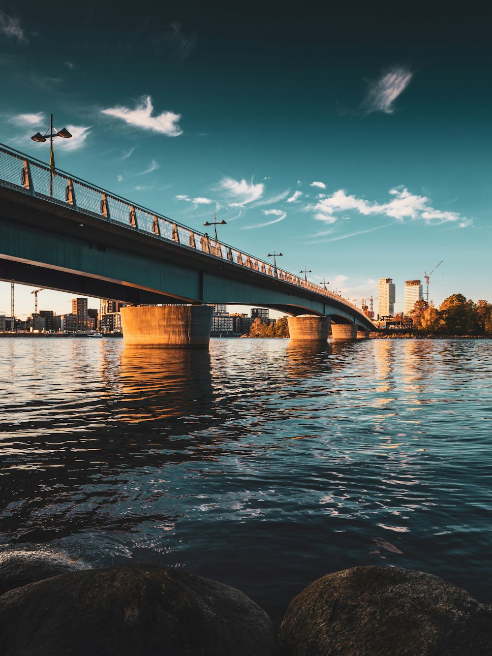 brown bridge over water under blue sky during daytime