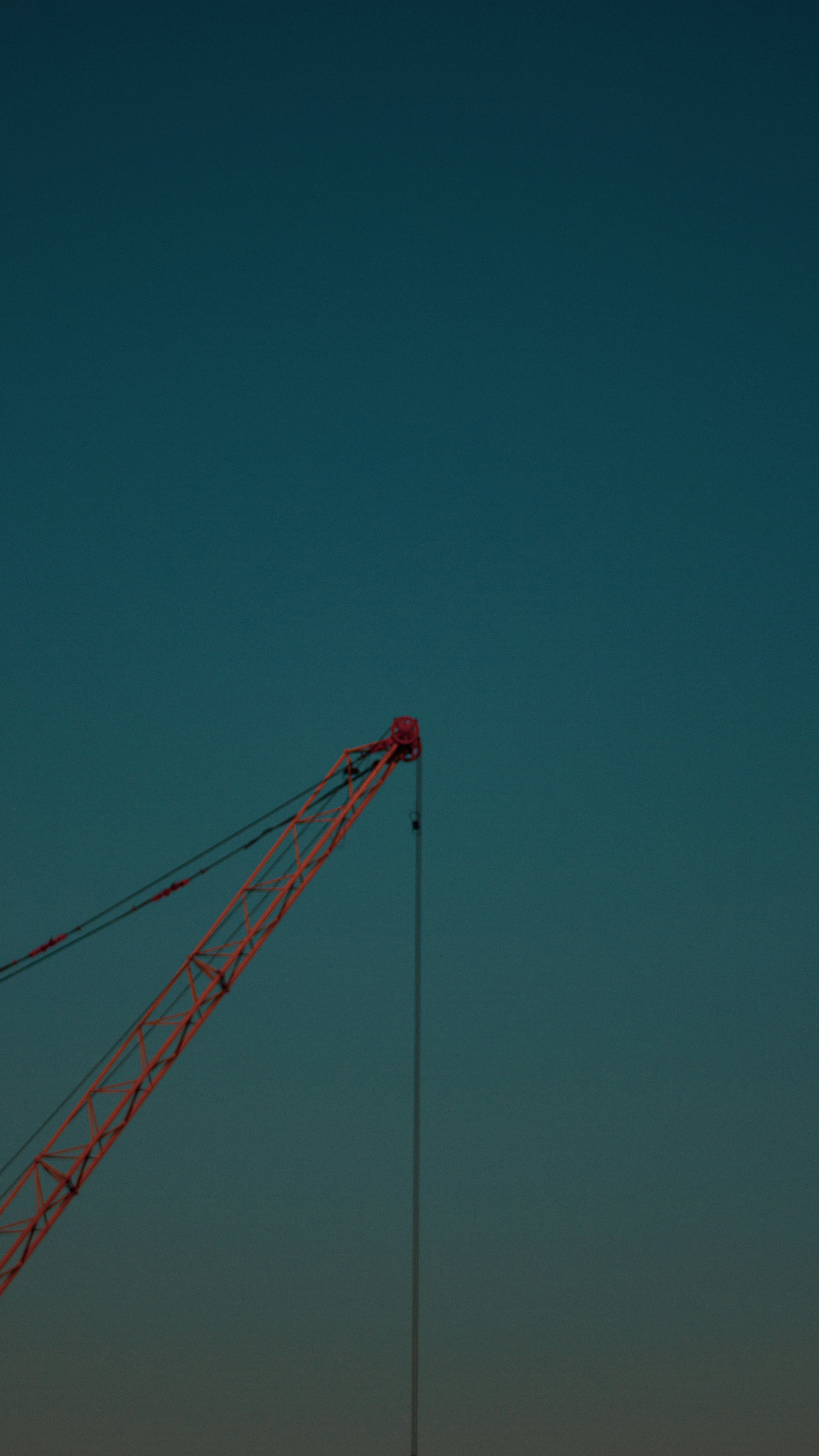 red crane under blue sky during daytime