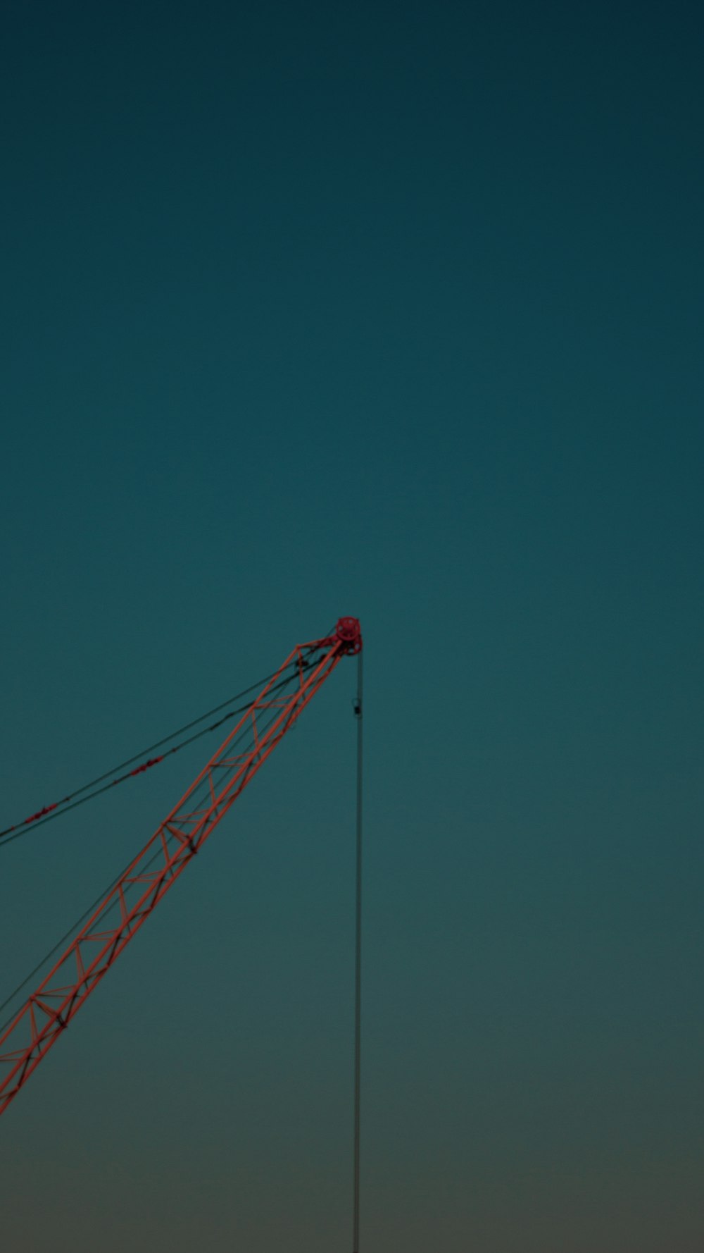 red crane under blue sky during daytime