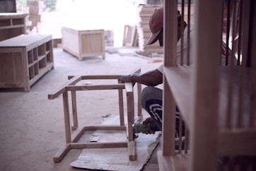 person in black shirt sitting on brown wooden chair