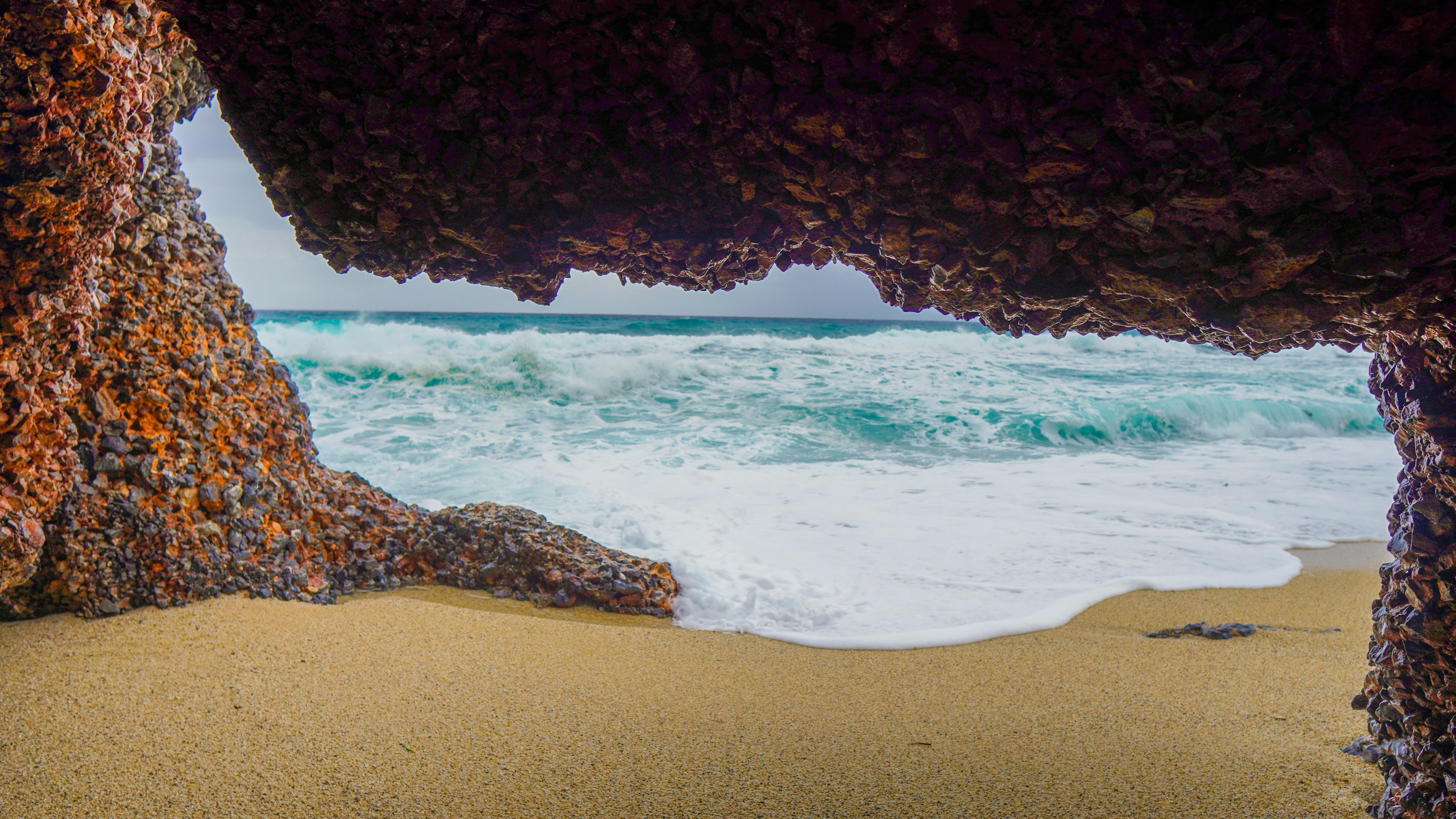 brown rock formation on sea shore during daytime, Alanya Cleopatra beach cave.