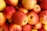 red and yellow apples on yellow plastic container