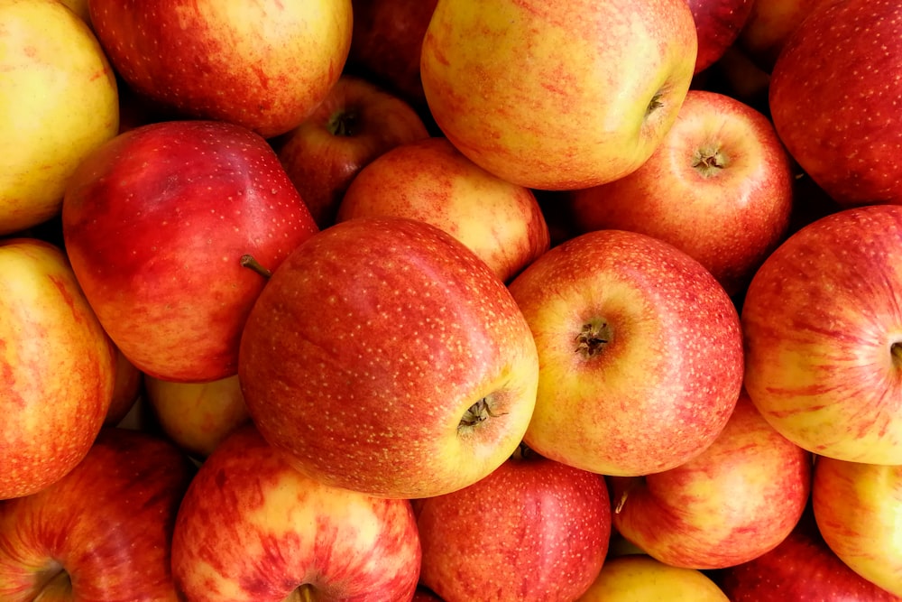 red and yellow apples on yellow plastic container