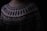 A close-up of a knitted sweater with intricate geometric patterns in black and white. The sweater has a high neckline and showcases various zigzag and dot designs. The lighting is dim, creating a cozy and warm atmosphere.