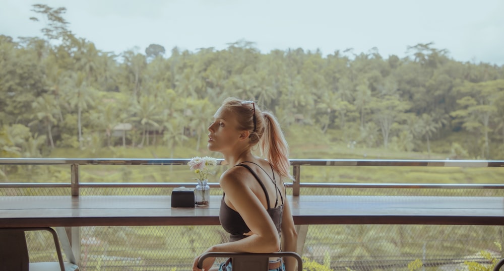 woman in black bikini sitting on bench during daytime