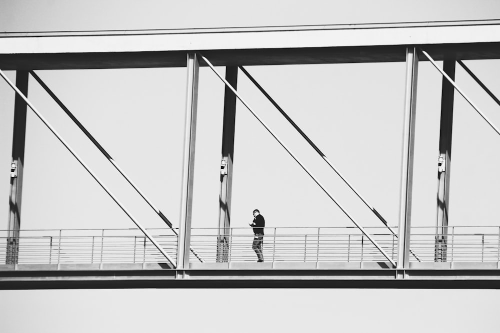 2 person walking on a bridge