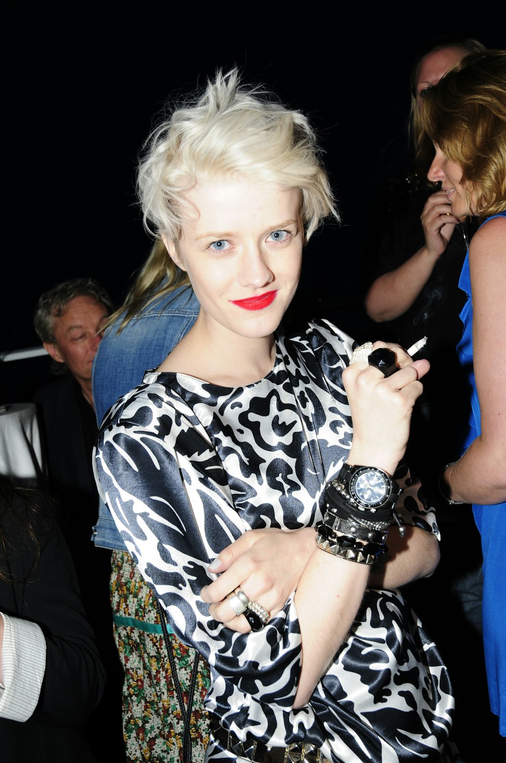 woman in black and white shirt holding black smartphone