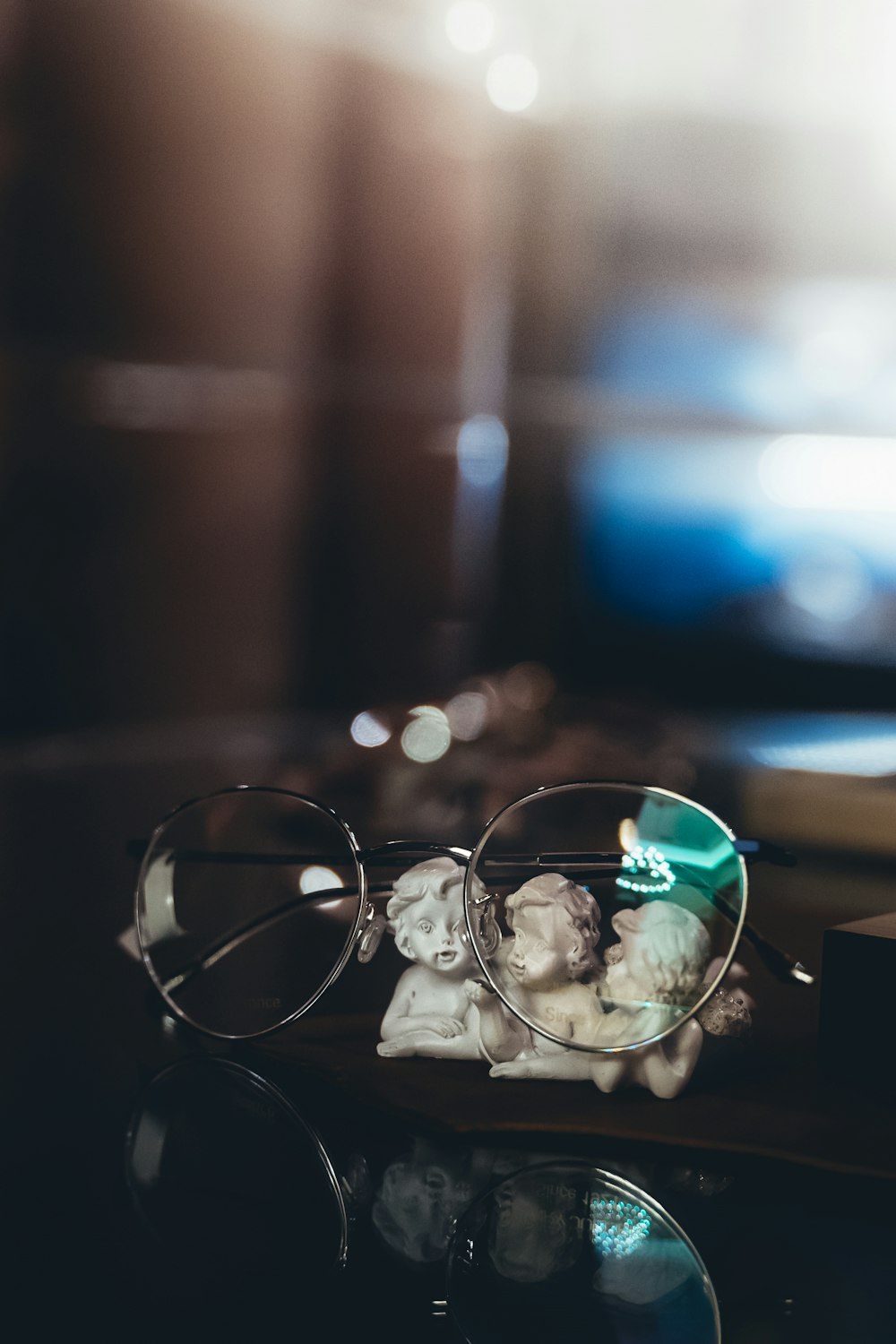 silver framed eyeglasses on brown wooden table