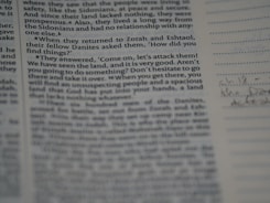 Close-up of hands reviewing and marking a printed text
